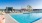 Large sparkling blue pool with a large pool deck and lounge chairs