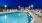 Large sparkling blue pool with a large pool deck and lounge chairs